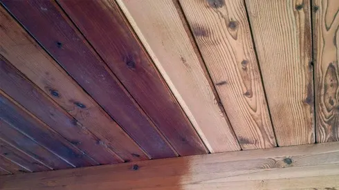 Plafond bois en cours de traitement avec l'aérogommeuse.